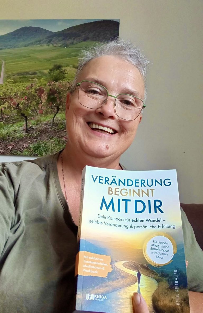 Leserin zeigt das Buch „Veränderung beginnt mit dir“ vor einer Landschaft